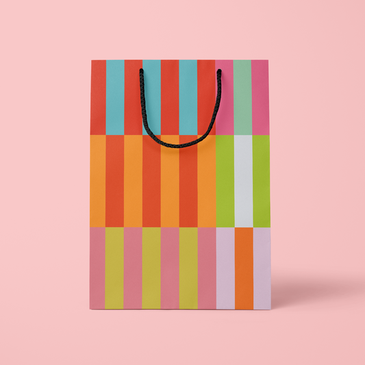 Colorful striped shopping bag on a pink background