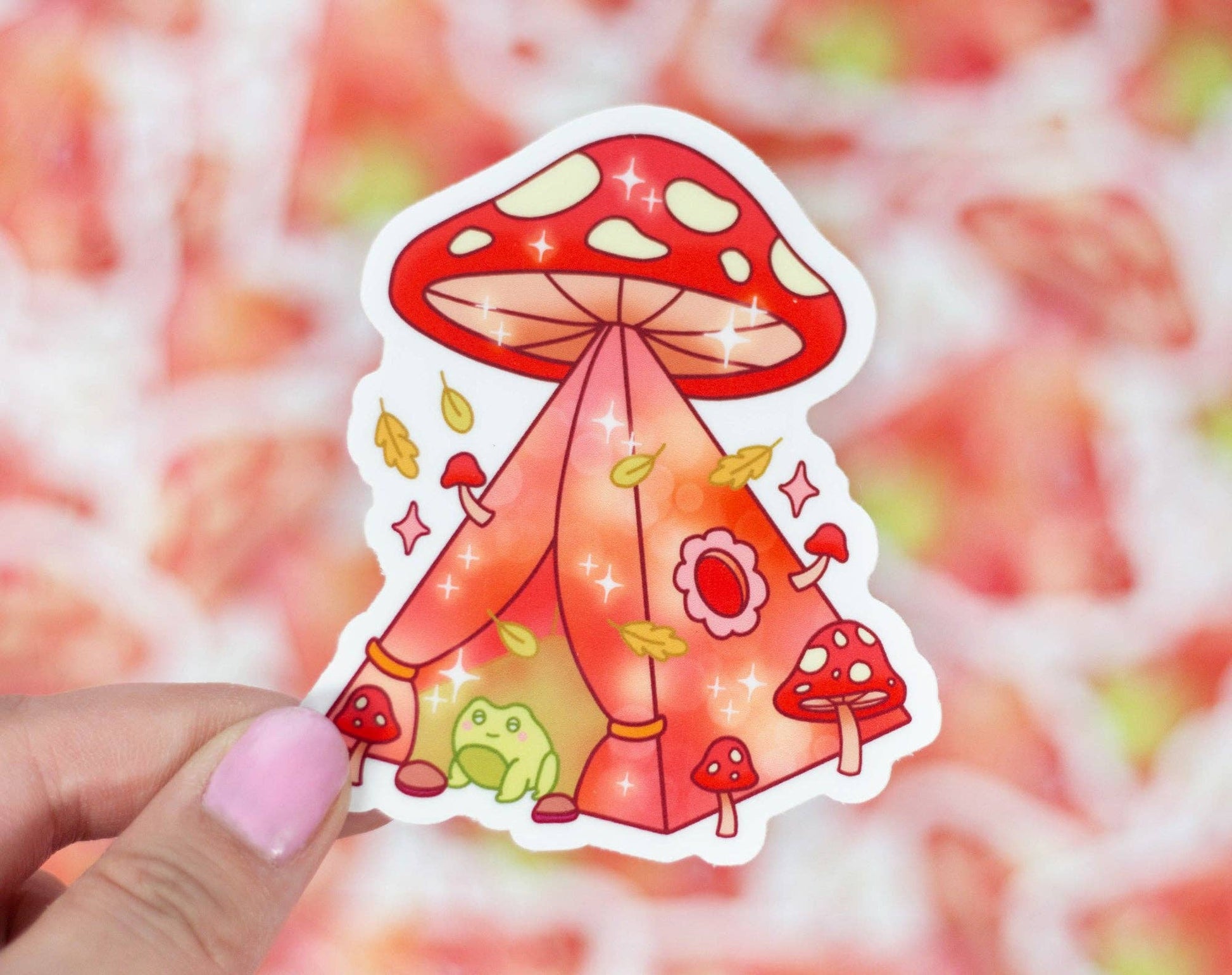 Sticker of a red mushroom with a tent-like structure held by a hand against a colorful background.