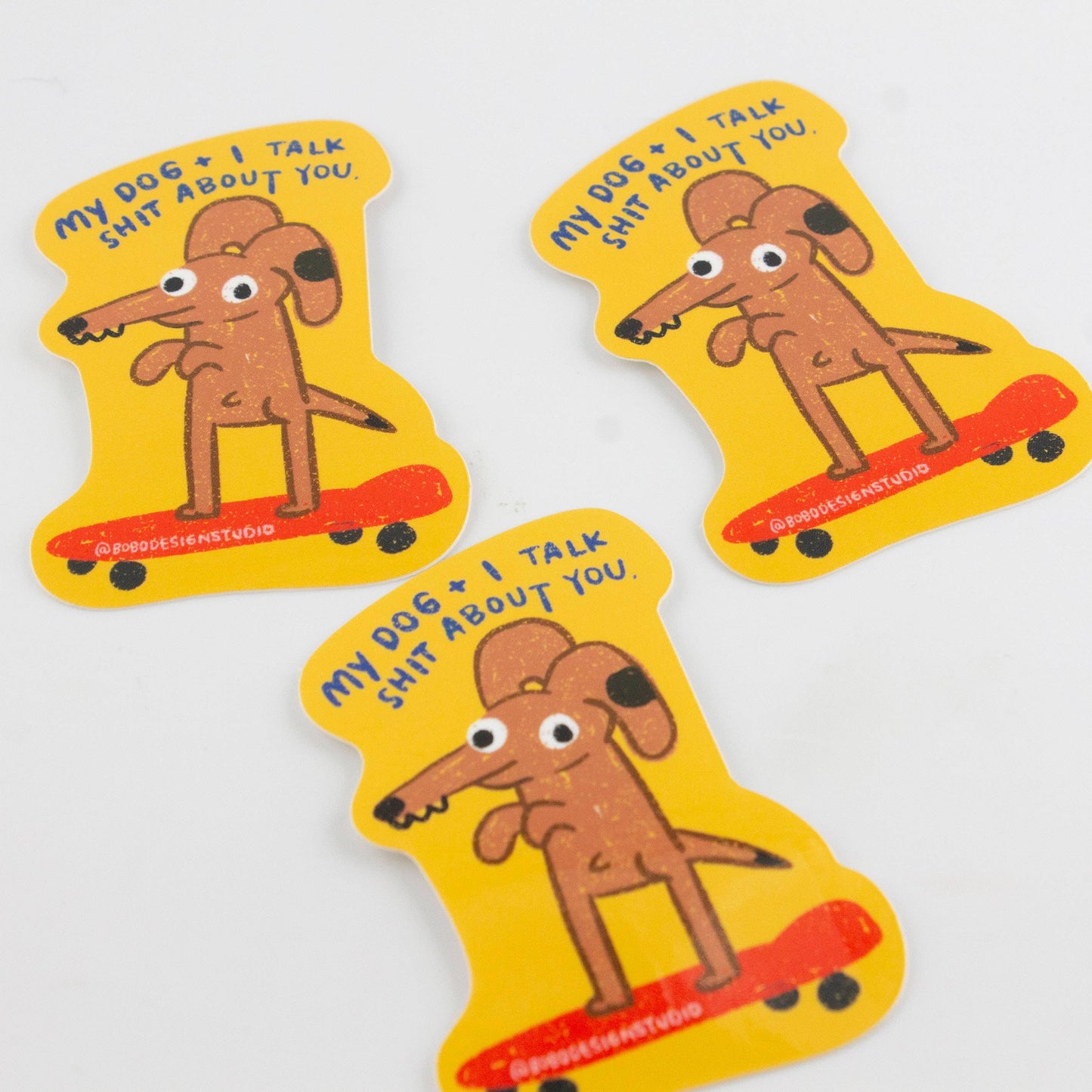 Three stickers with a cartoon dog and text on a white background