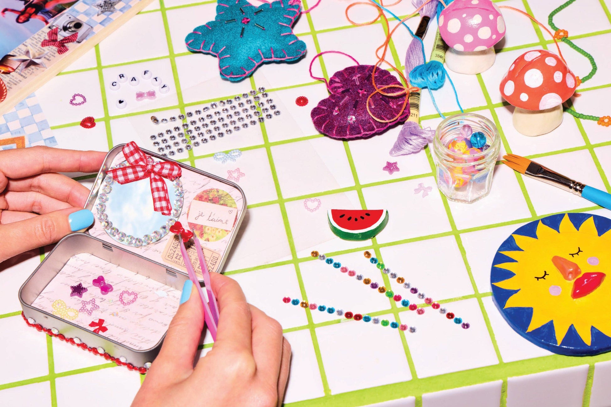 Crafting activity with decorative items and tools on a grid surface