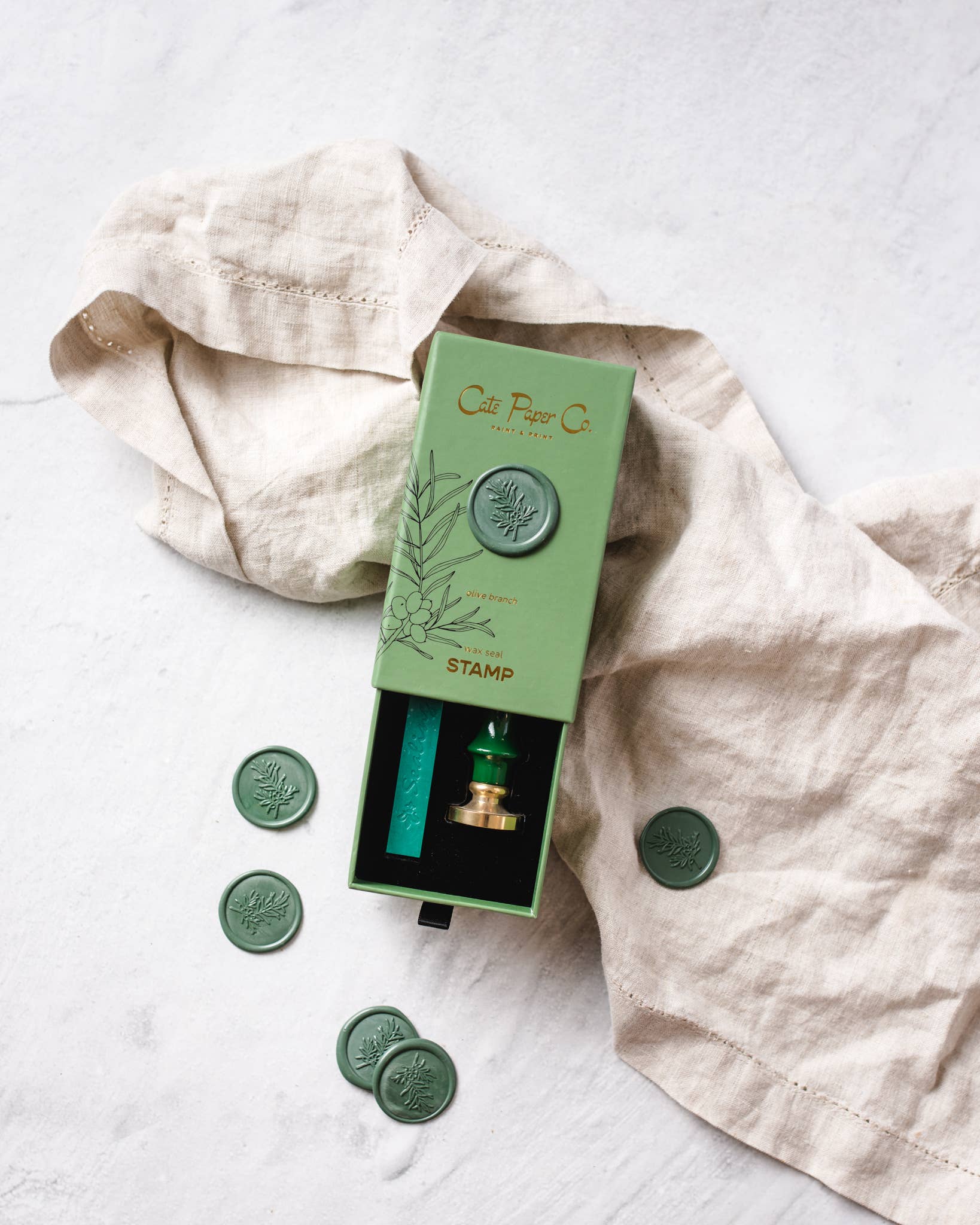 Green stamp set with packaging on a light fabric background