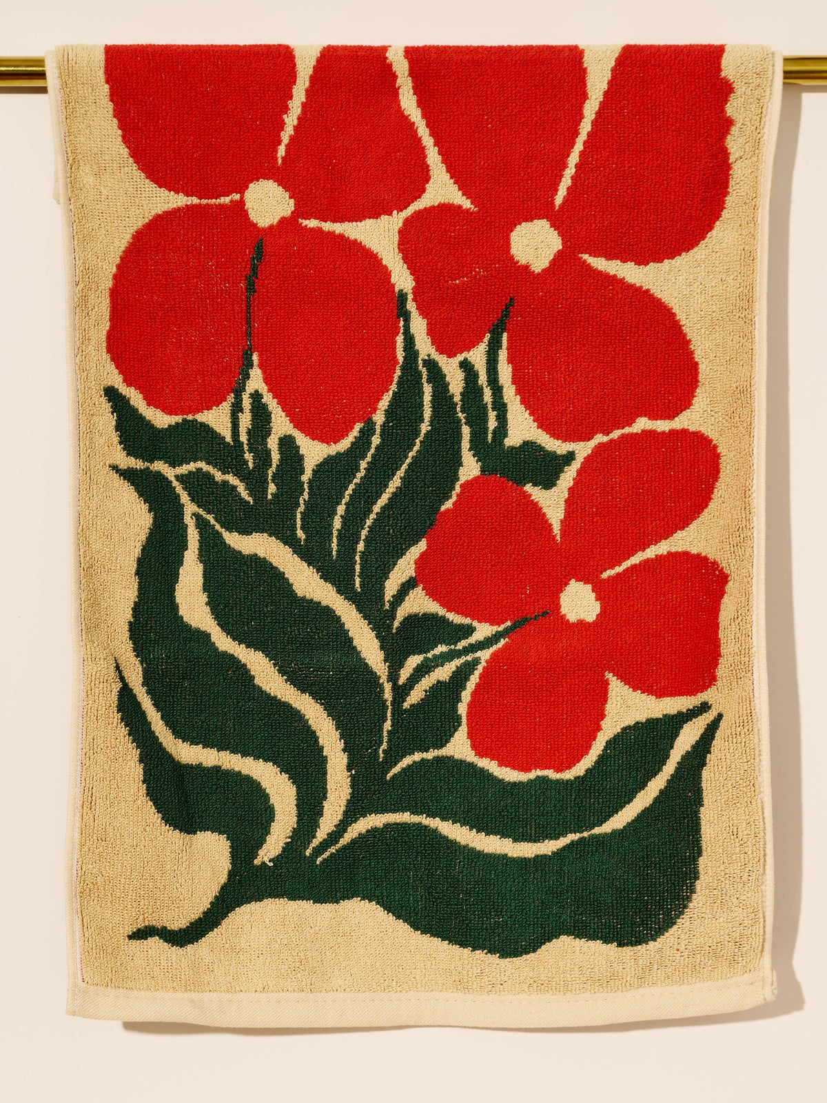 Beige towel with red floral pattern on a gold rod background
