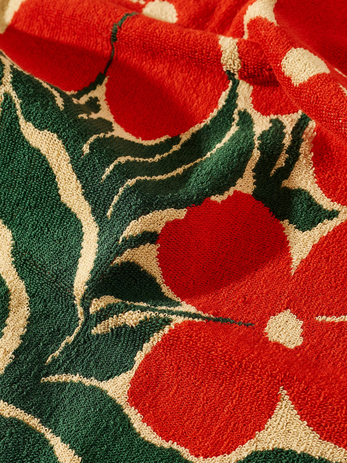 Close-up of a red floral pattern on a textured fabric background