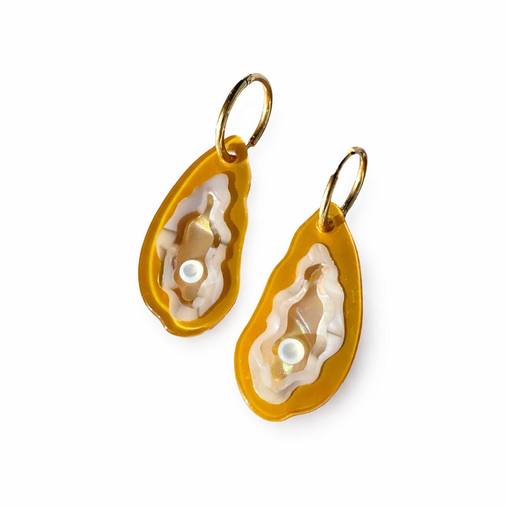 Gold and white earrings on a white background