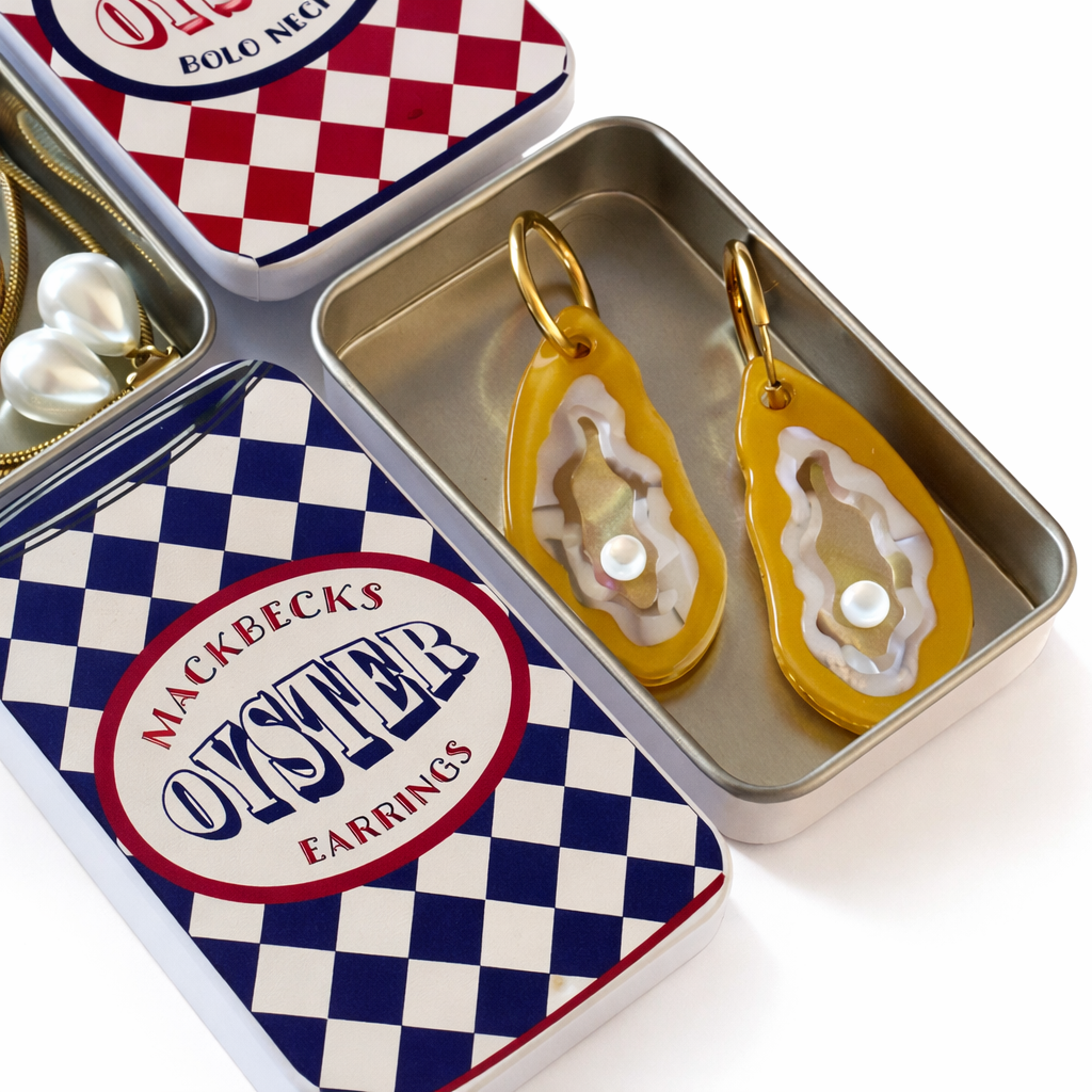 Yellow oyster-shaped earrings in a checkered tin with 'Mackbecks Oyster Earrings' branding.