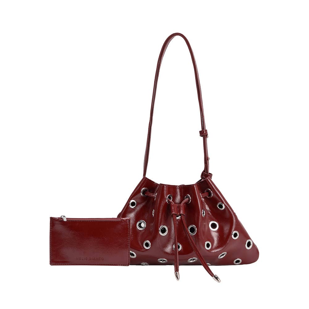 Brown leather handbag with grommet details on a white background