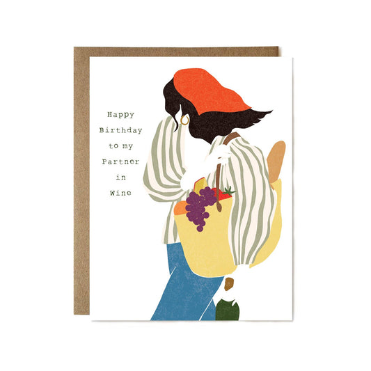 Greeting card with illustration of a person holding a bag of grapes and text 'Happy Birthday to my Partner in Wine' on a white background.