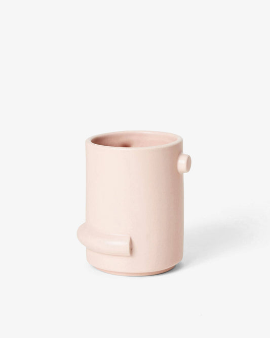 Pink ceramic vase with a handle on a white background