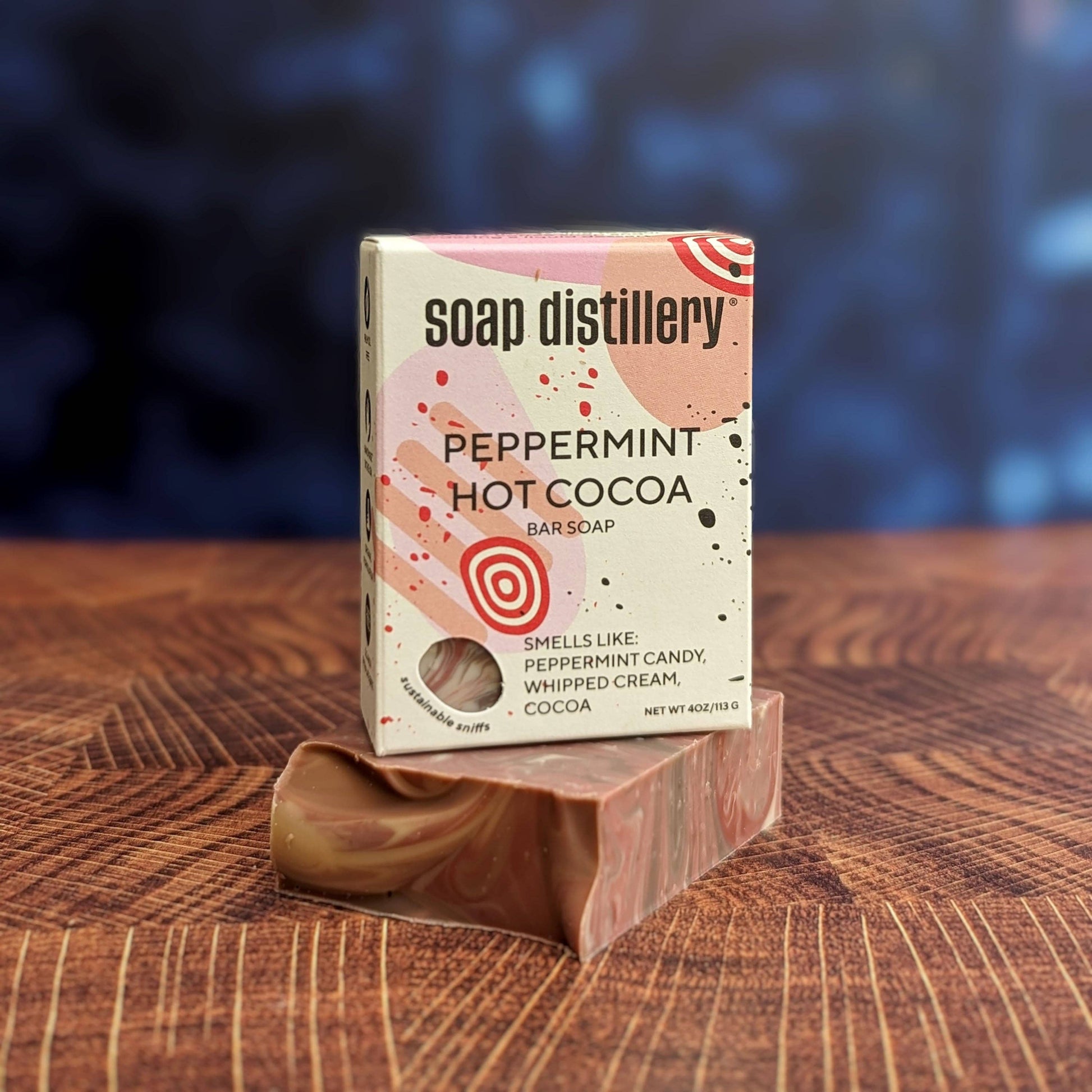 Soap distillery peppermint hot cocoa soap bar with packaging on a wooden surface. Peppermint Hot Cocoa Bar Soap