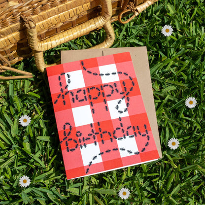 Checkered birthday card with 'Happy Birthday' on grass