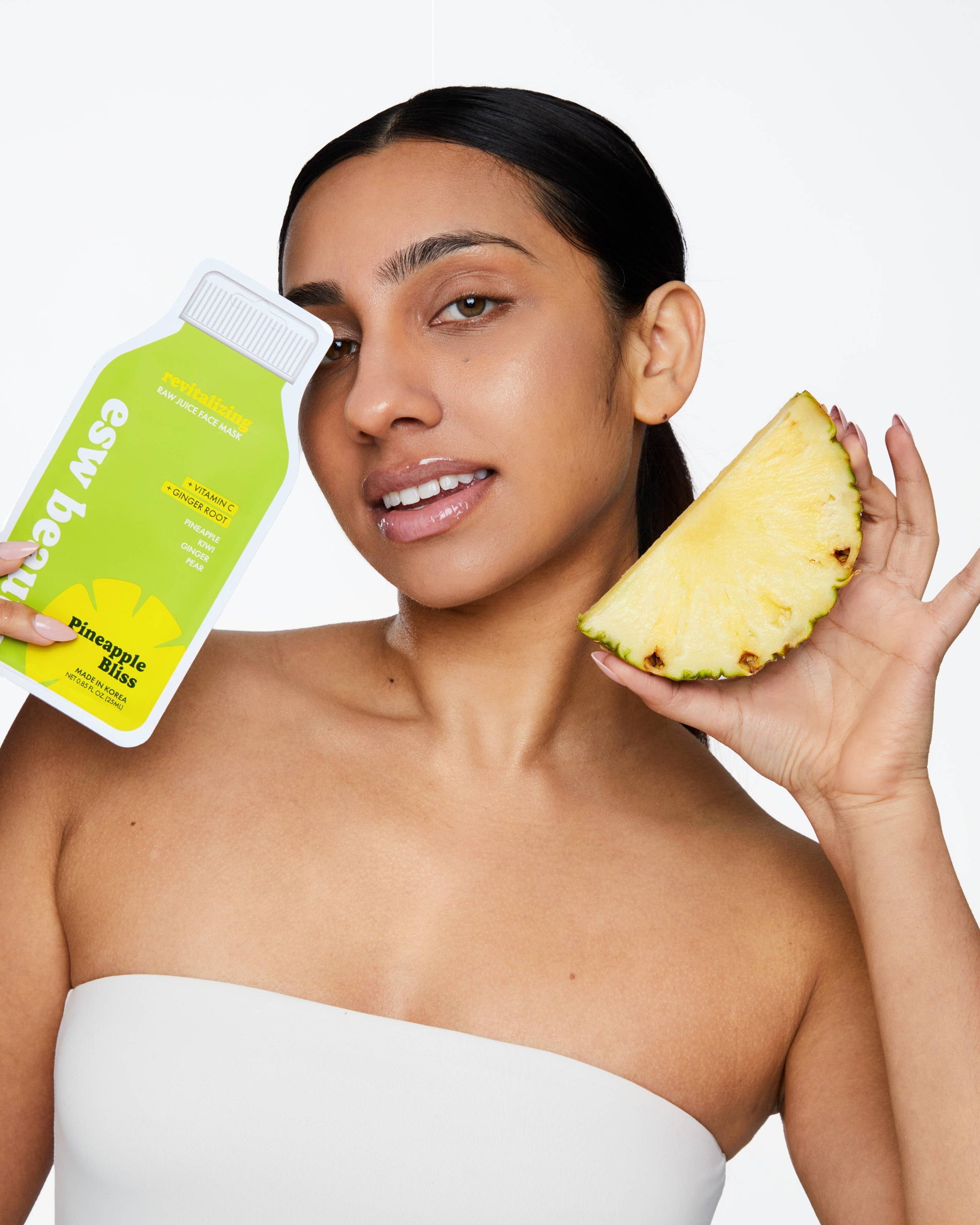 Woman holding a pineapple and a bottle of 'Easy Beauty' product on a white background