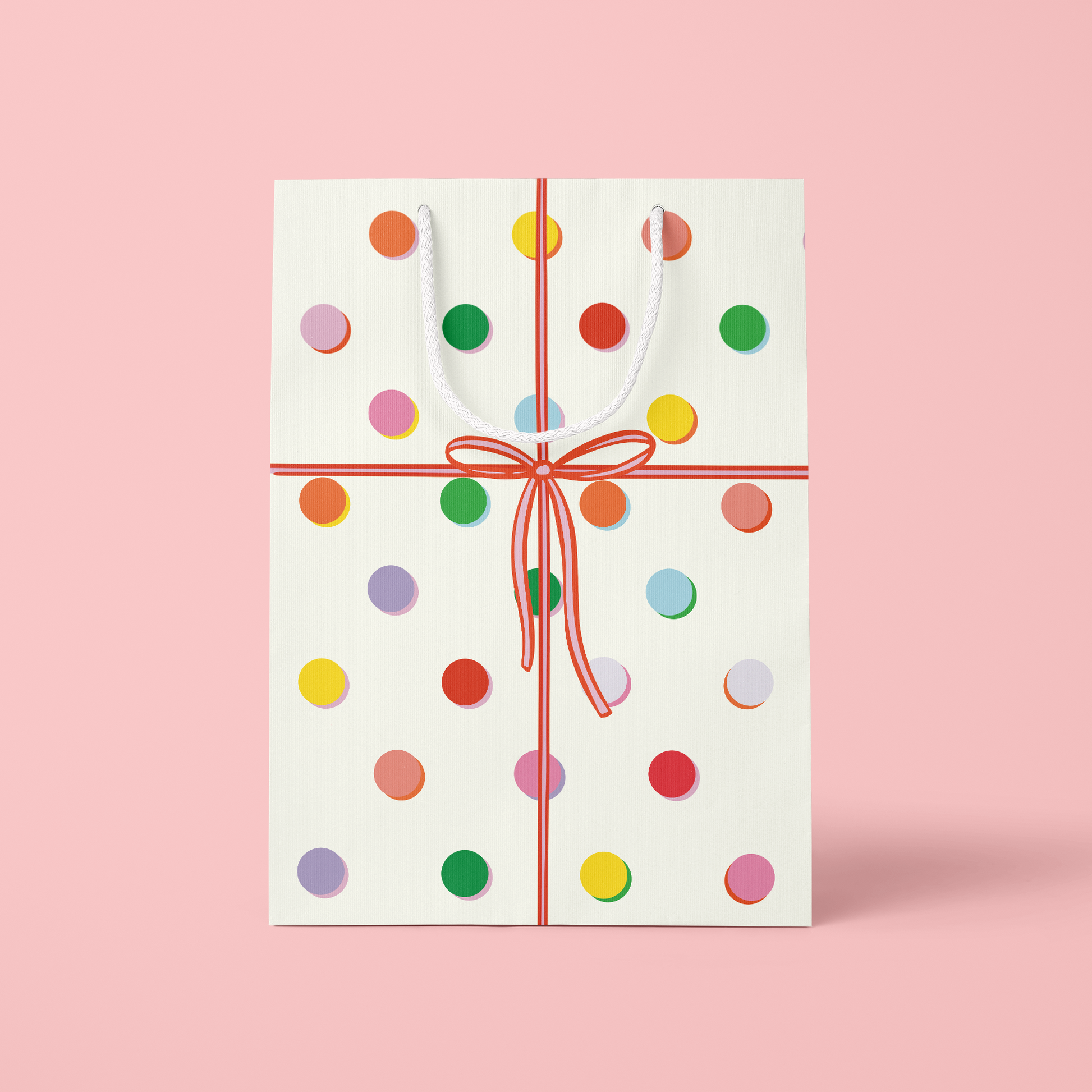 Gift card with colorful polka dots and a red ribbon on a pink background