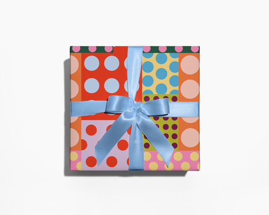 Colorful polka dot gift box with a blue ribbon on a white background