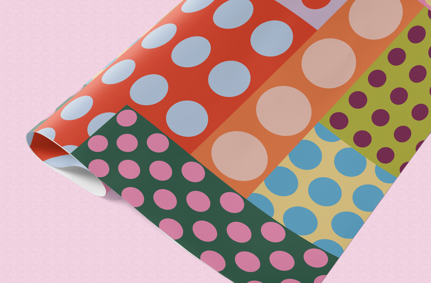 Colorful polka dot patterned paper on a pink background