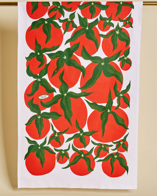 Tea towel with red tomato pattern on a white background