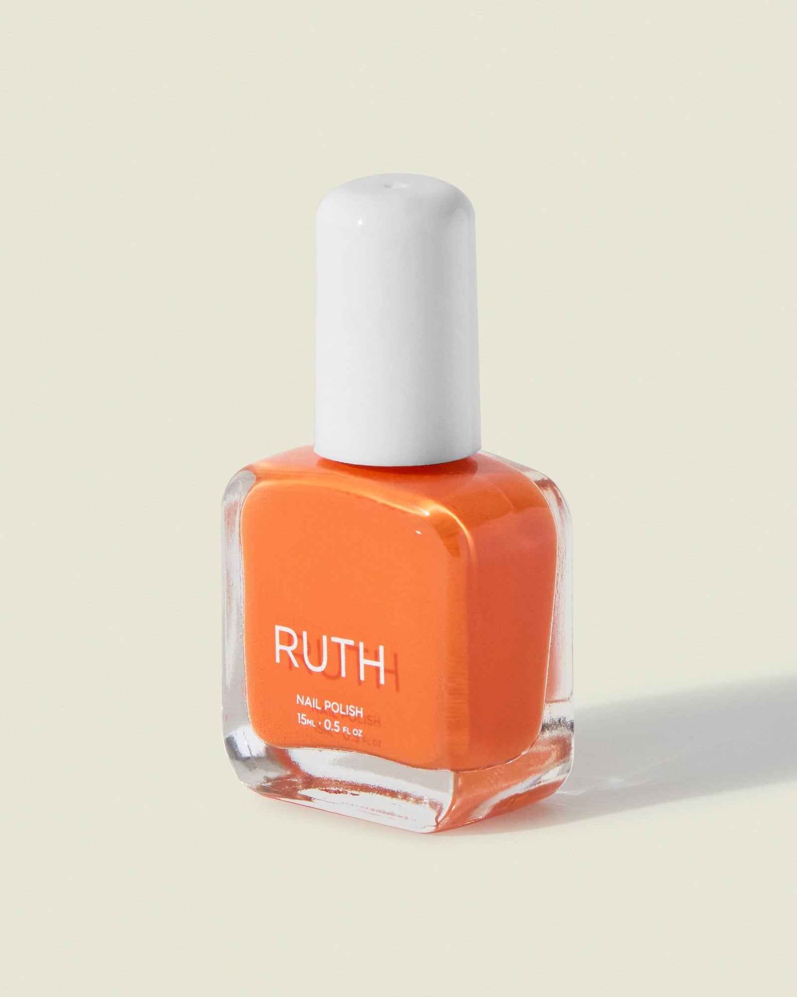 Orange nail polish bottle with white cap on a light beige background, Prawn Orange Nail Polish, ruth polish