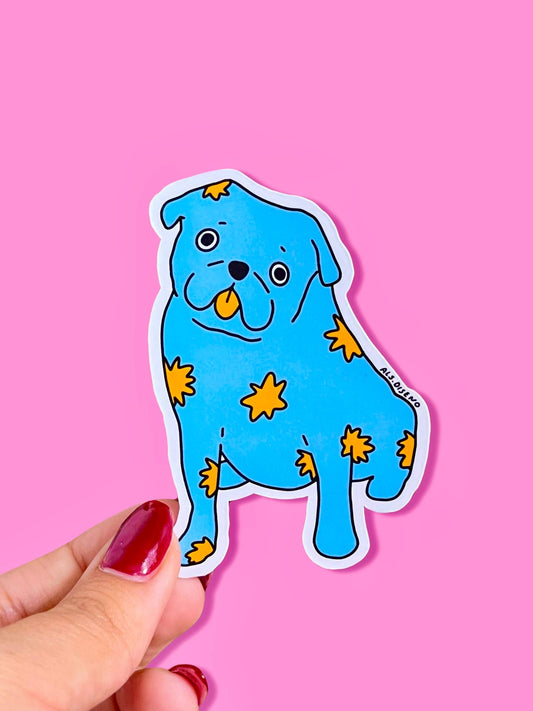 Blue dog-shaped sticker with yellow stars held by a hand against a pink background