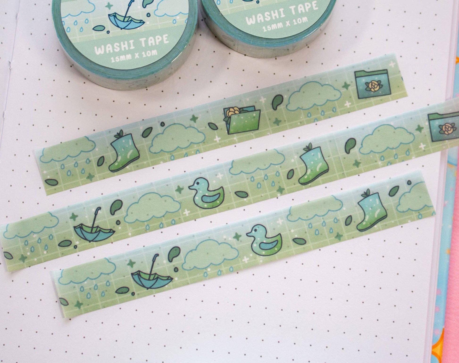 Two rolls of washi tape with green and blue designs on a white background