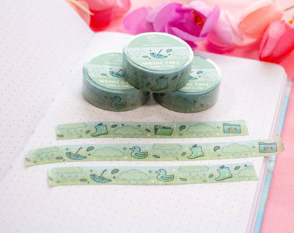 Green washi tape with duck design on a notebook with pink flowers in the background