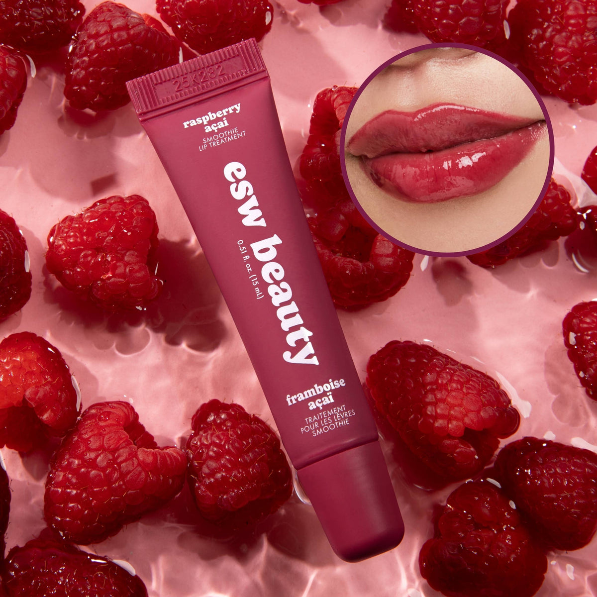 Lip balm tube with raspberries on a pink background