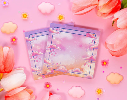 Two colorful sticky notes with cloud designs on a pink background with flowers