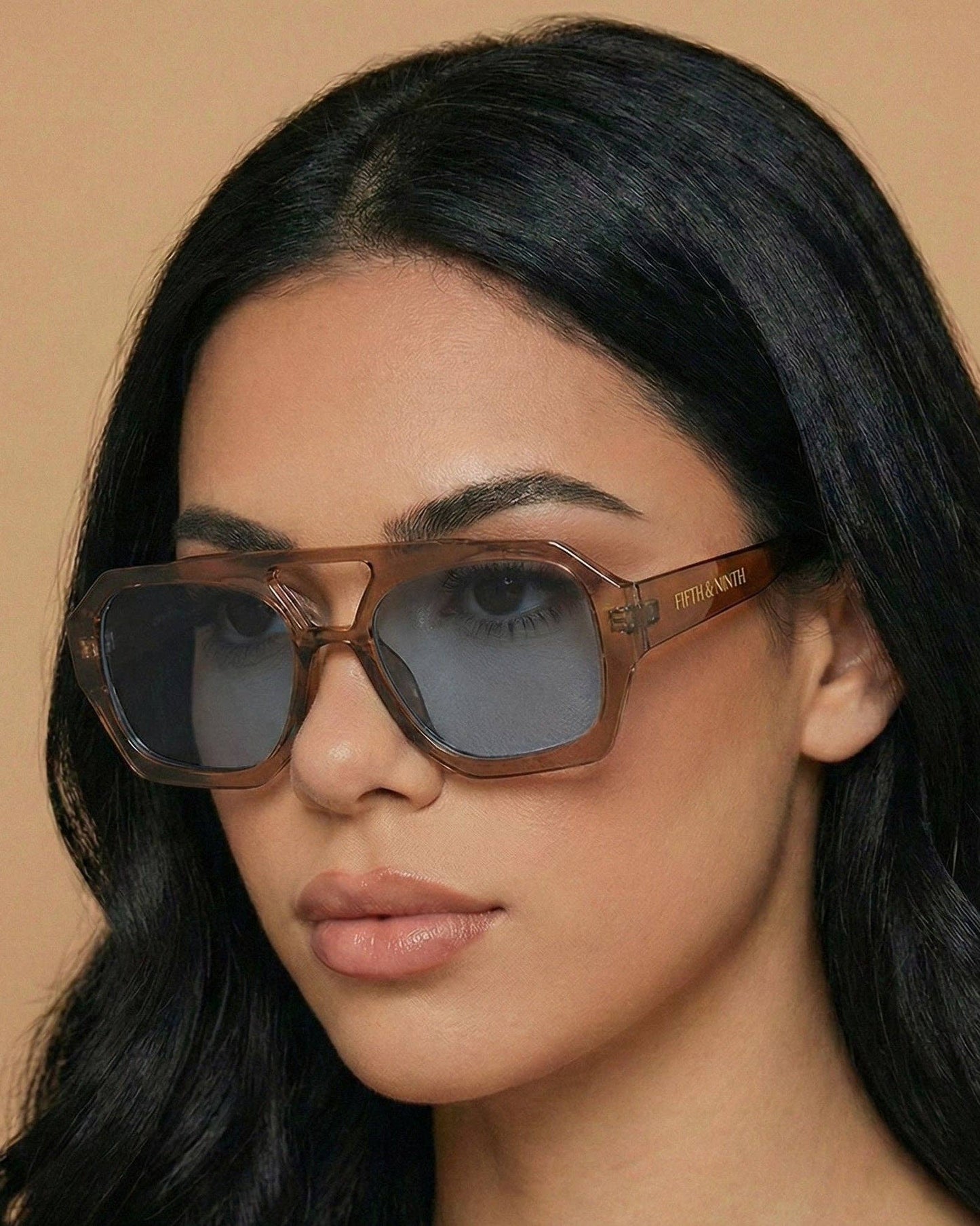 Woman wearing sunglasses with a neutral background