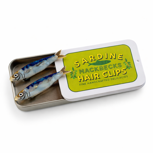 Sardine-shaped hair clips in a tin labeled 'Sardine Nackbecks Hair Clips' on a white background