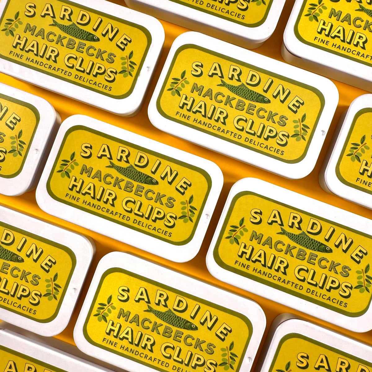 Pattern of Sardine Mackbecks Hair Clips packaging with yellow labels.
