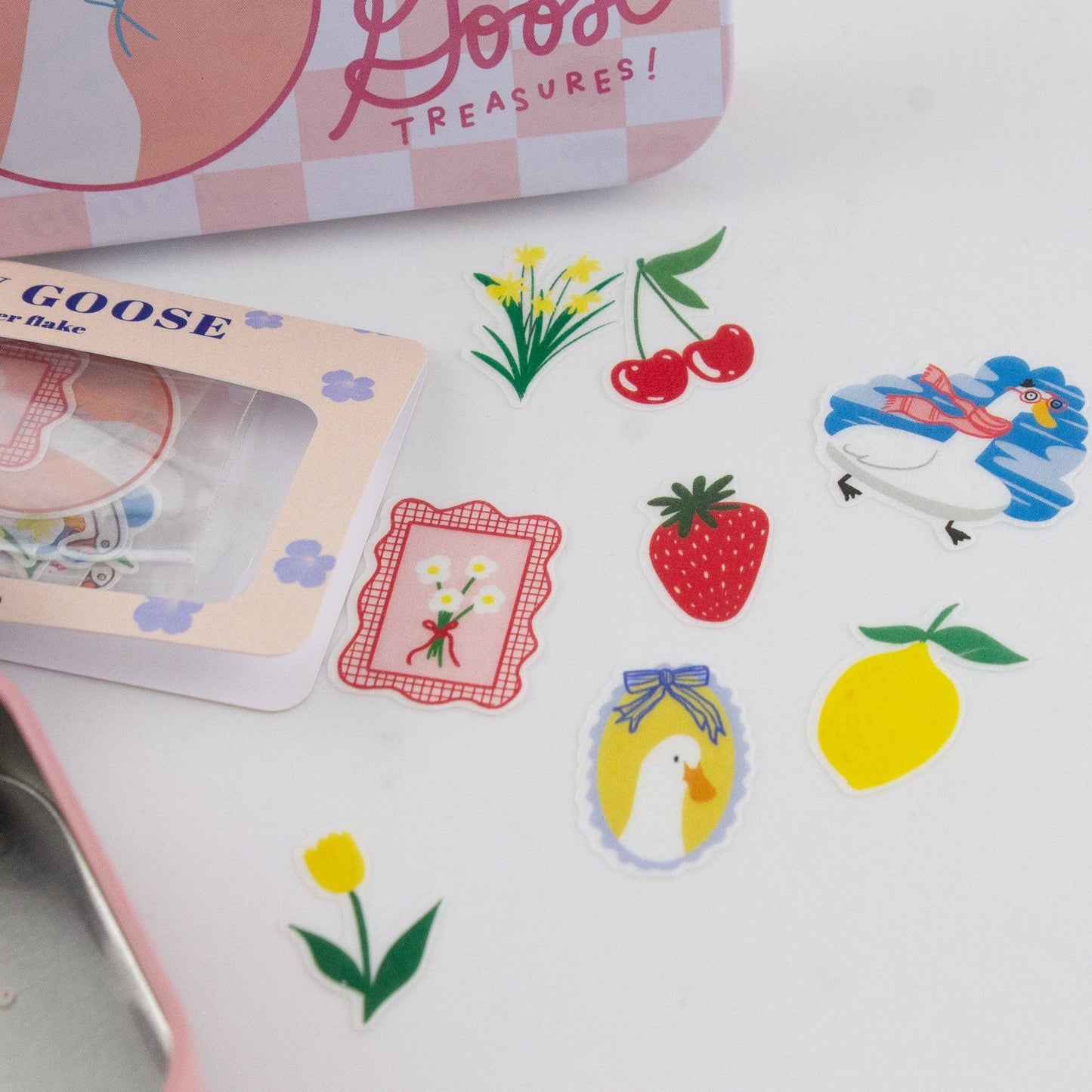 Set of colorful stickers featuring a goose, strawberry, lemon, and other designs on a white surface.