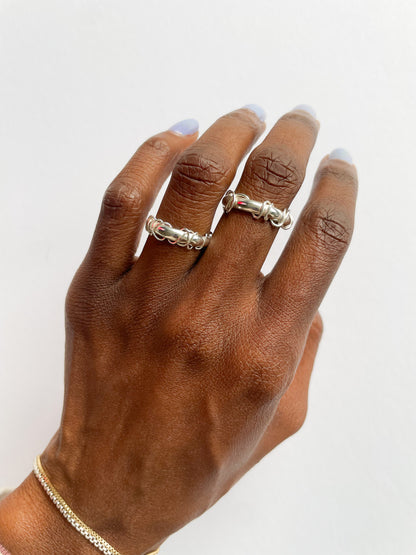 Hand wearing a silver ring on a white background