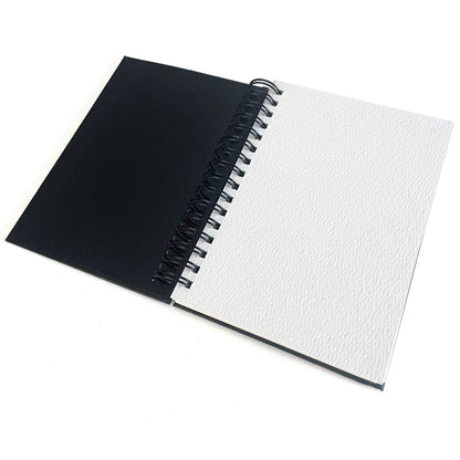 Open notebook with black cover and white textured pages on a white , Small Watercolor Paper Padbackground