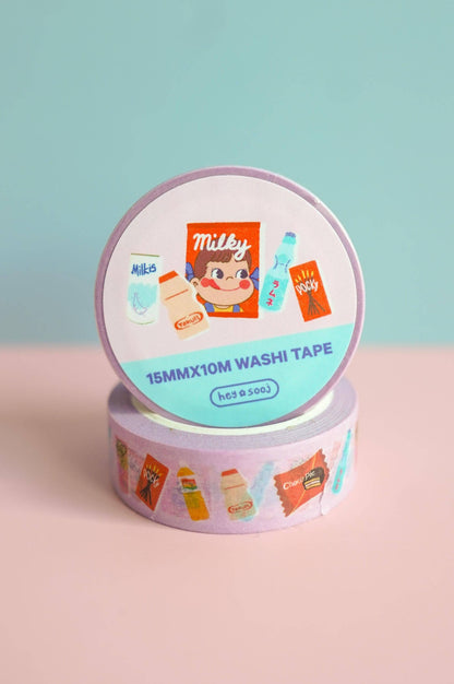 Roll of Milky washi tape with colorful designs on a pink surface and light blue background