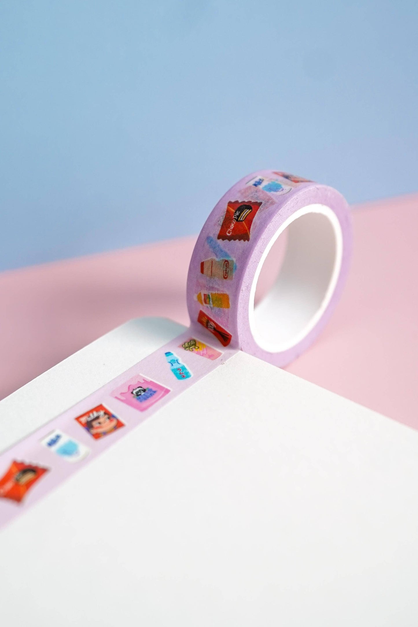 Decorative tape with colorful designs on a pink surface against a light blue background