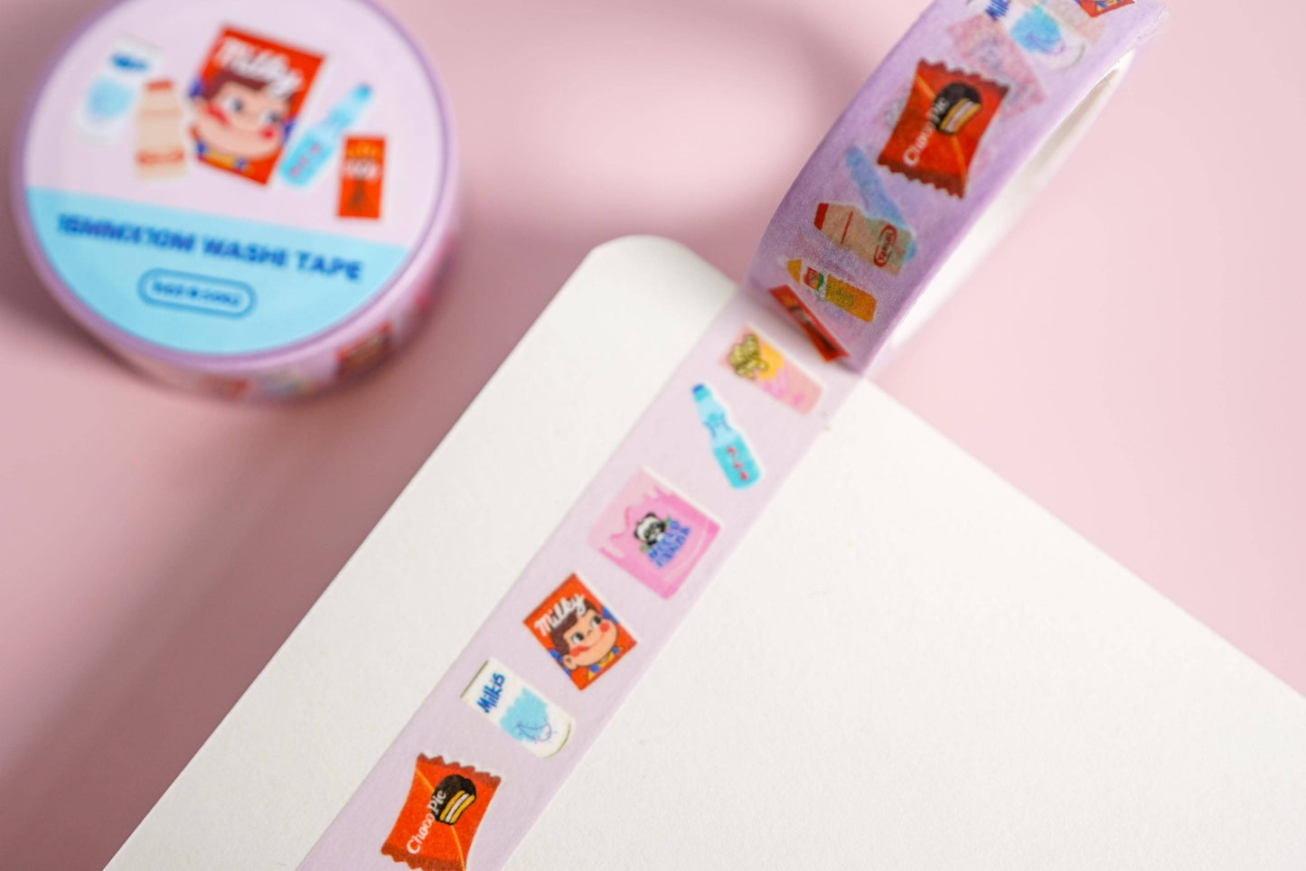 Decorative washi tape with cartoon designs on a pink background