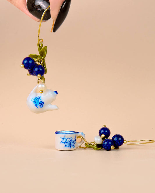 Earrings with ceramic teacup and teabag design on a beige background, Spill the Tea Earrings