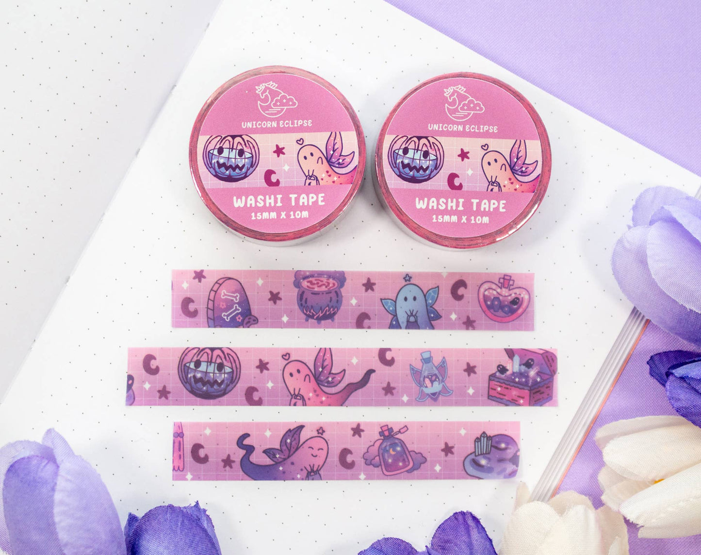 Two pink washi tape containers with decorative tapes on a white background