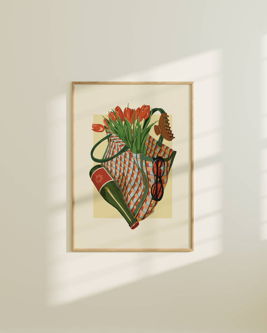 Framed artwork of a still life with flowers and a bag on a beige wall.