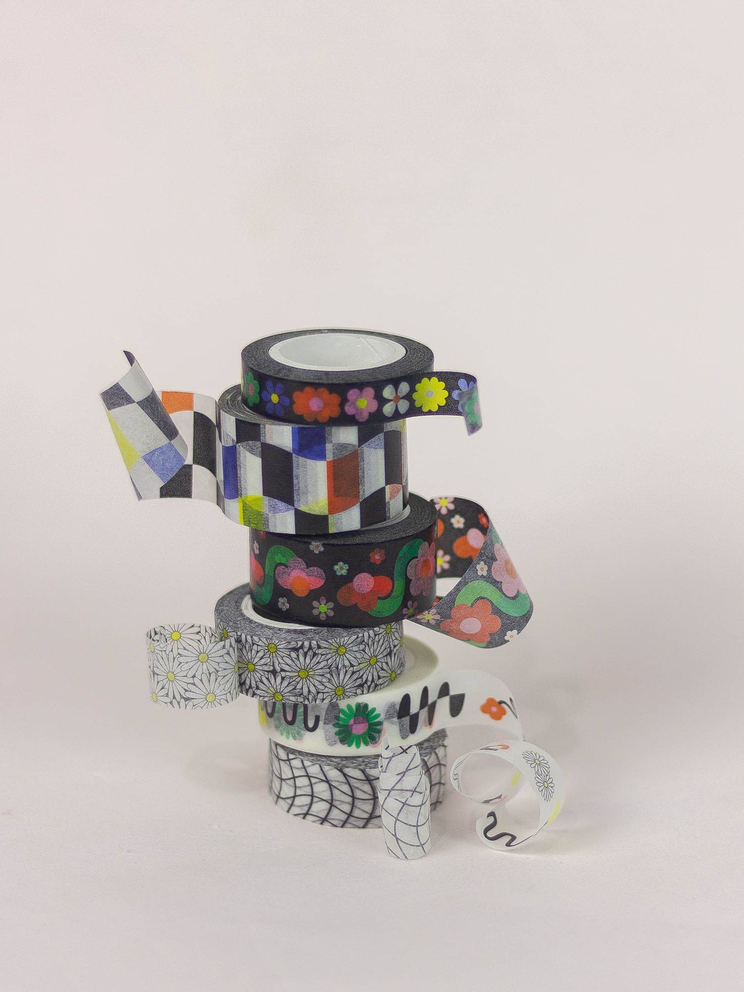 Stack of colorful washi tape rolls on a white background