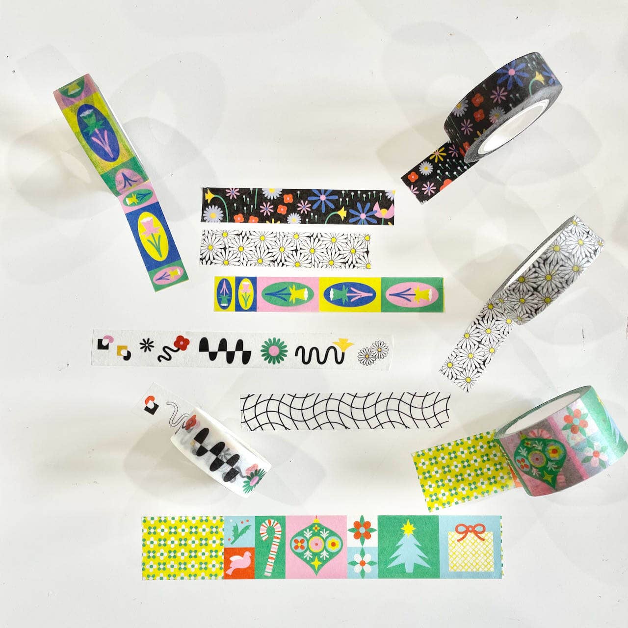 Collection of colorful washi tape rolls with various patterns on a white background