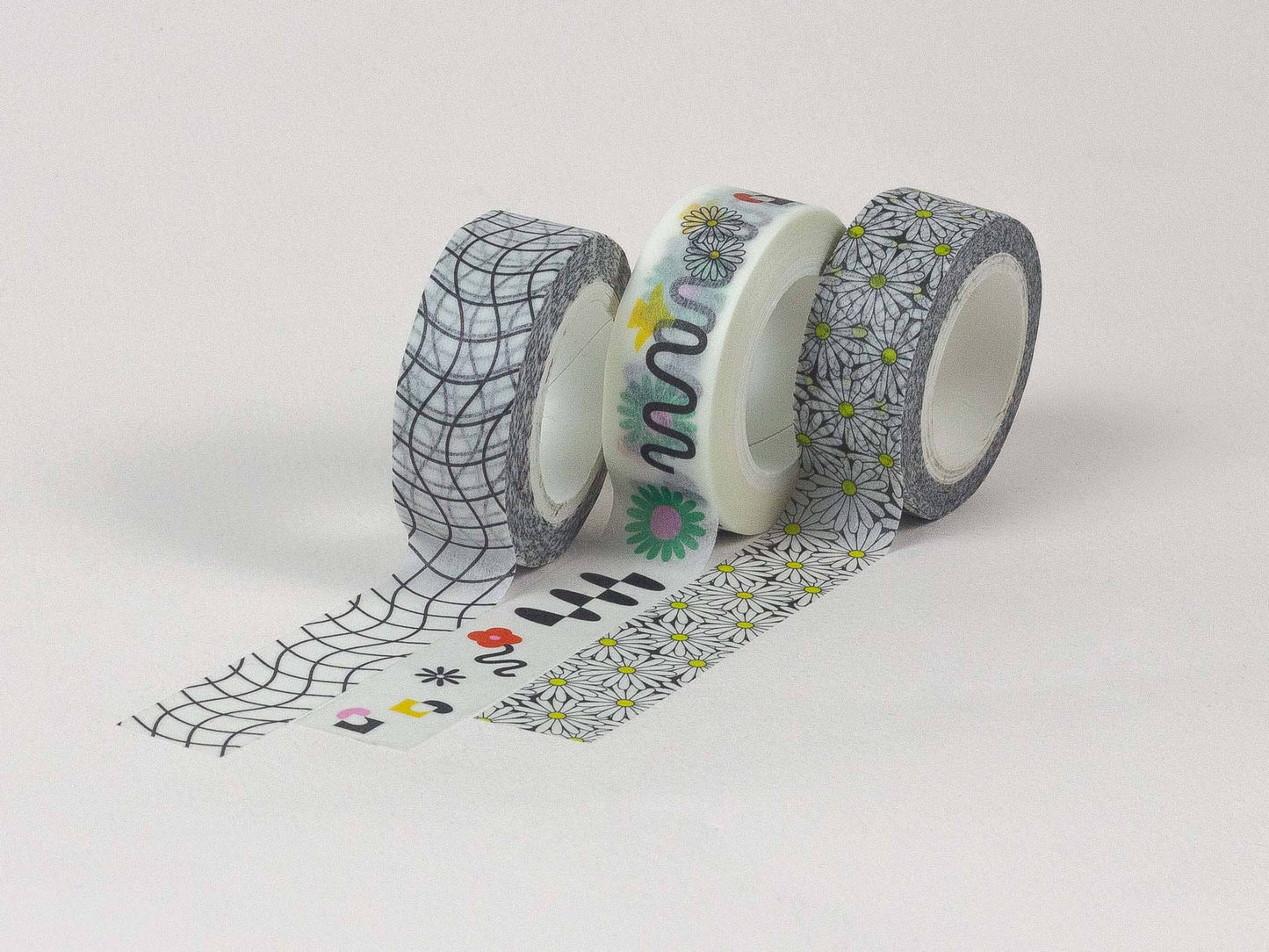 Three rolls of decorative tape with unique patterns on a white background