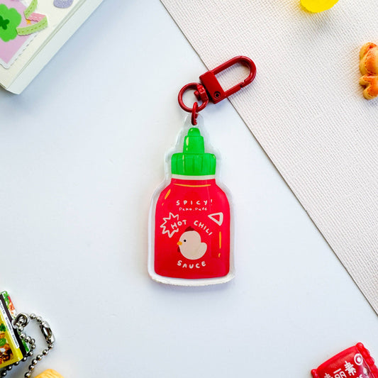 Spicy hot chili sauce keychain on a light gray background