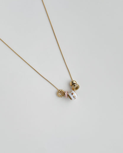 Necklace with a small pendants on a light gray background. Starry Baubles Necklace