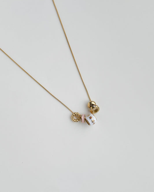 Necklace with a small pendants on a light gray background. Starry Baubles Necklace