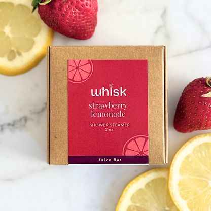 Whisk strawberry lemonade shower steamer packaging with lemons and strawberries on a marble background
