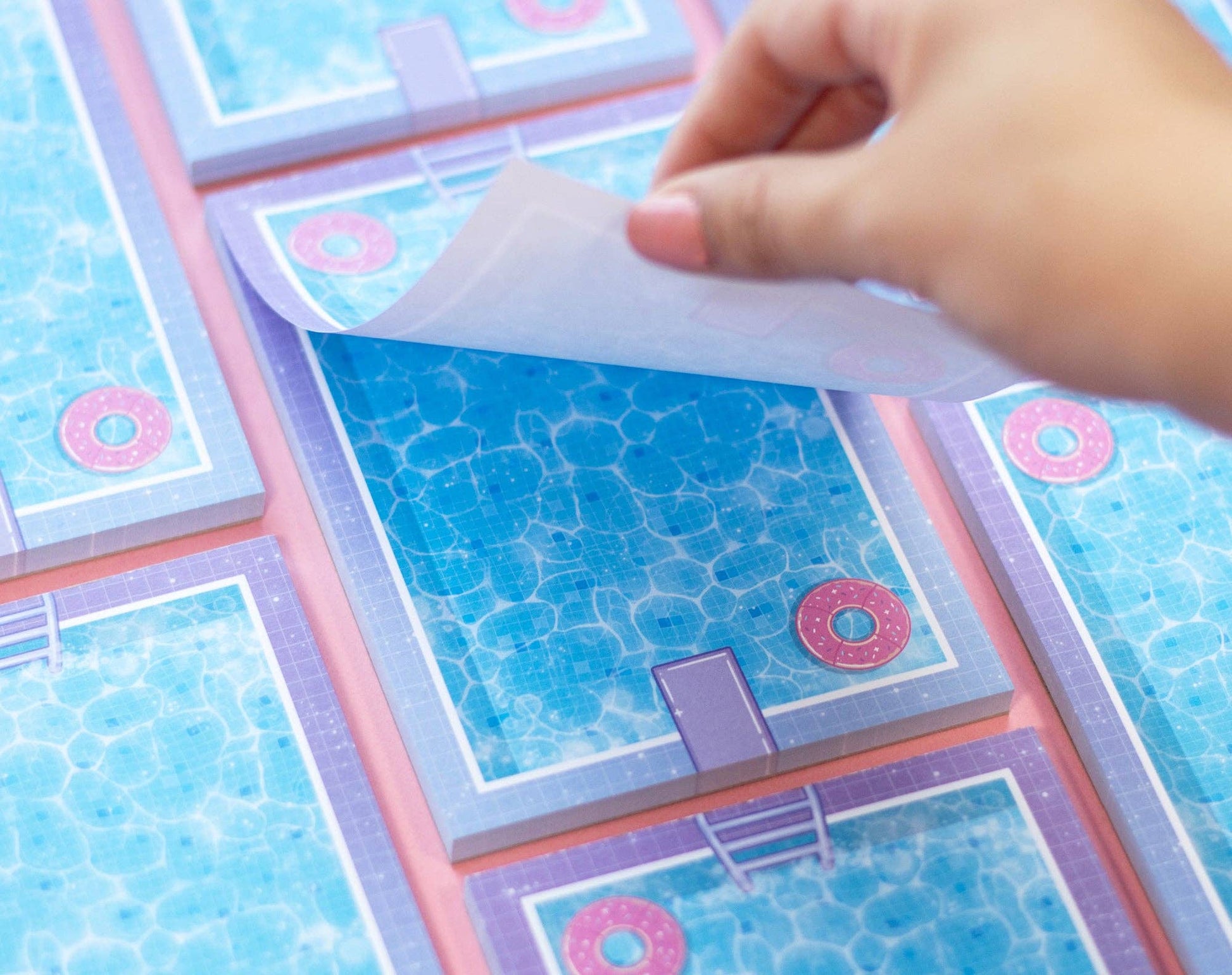 Hand lifting a page with pool design from a notepad