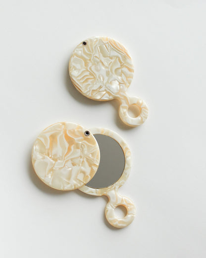 Swivel Pocket Mirror Pair of decorative earrings with circular designs on a light gray background