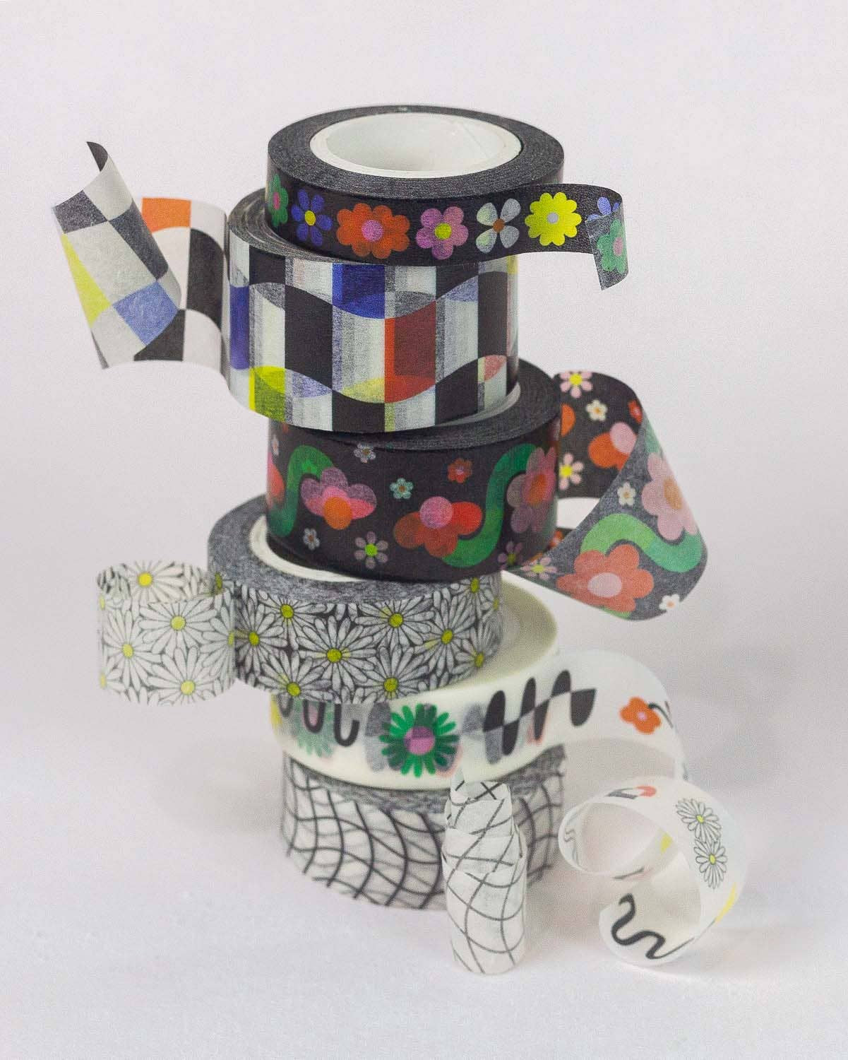 Colorful tape dispenser stack with decorative tapes on a white background