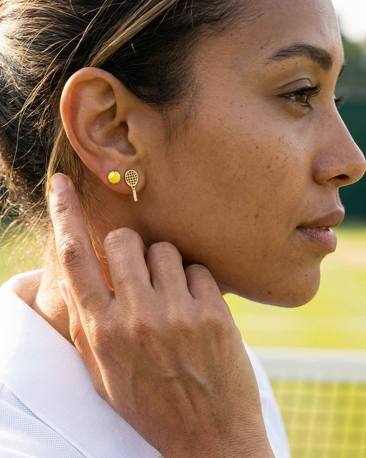 Close-up of a woman wearing gold earrings with a blurred background