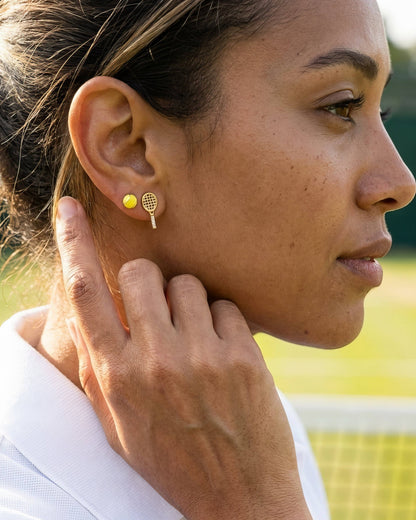 Close-up of a woman wearing gold earrings with a blurred background