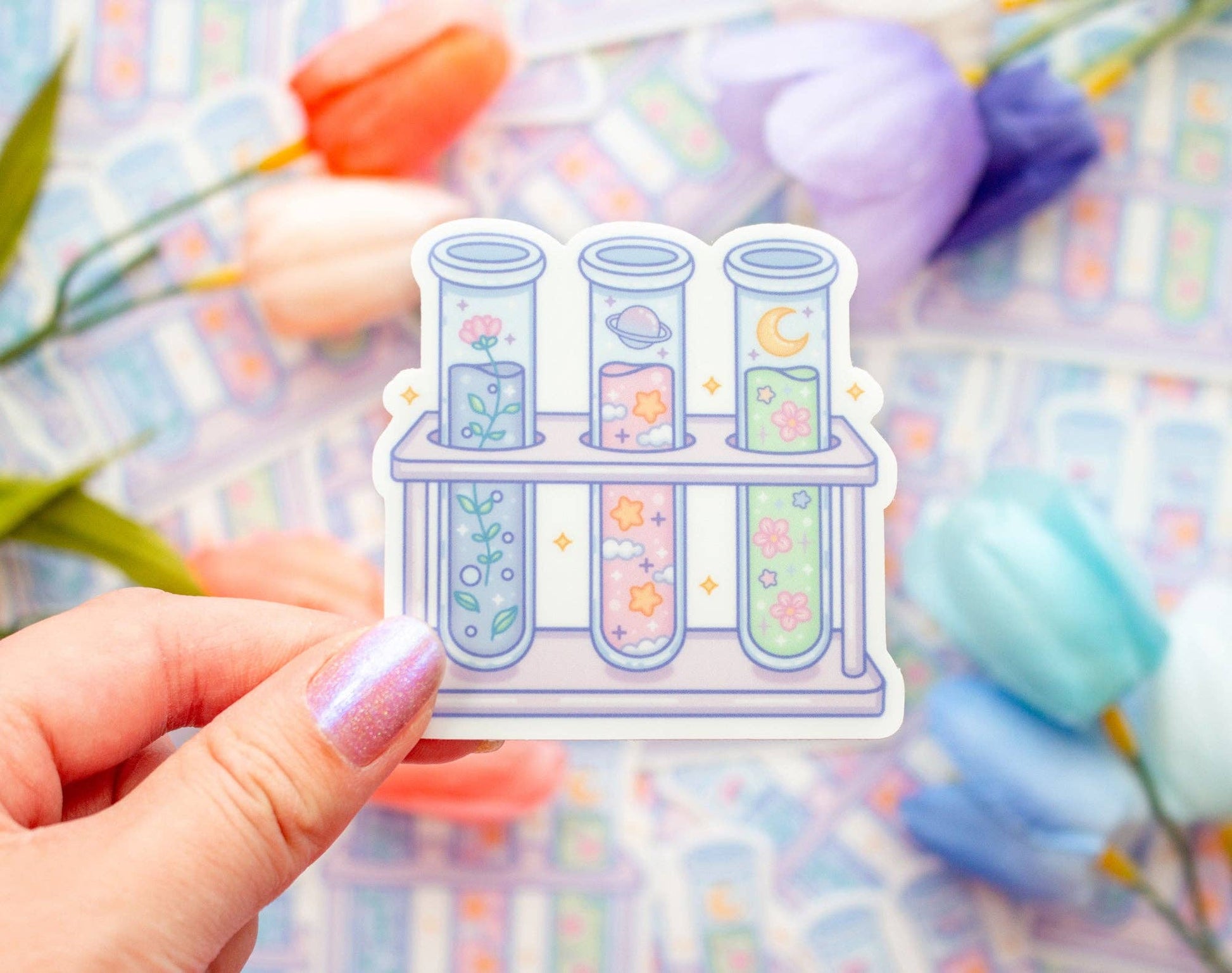 Sticker of test tubes with floral designs held by a hand against a colorful blurred background